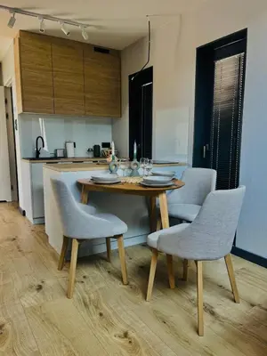 a kitchen with a wooden table and chairs in a kitchen at Green Garden Zielonki 14d in Bibice