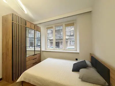 a bedroom with a bed and two windows at Pawlikowskiego nest - 5 minutes walk to Main Square in Kraków