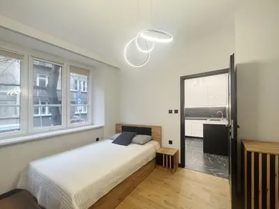 a bedroom with a bed and a large window at Pawlikowskiego nest - 5 minutes walk to Main Square in Kraków