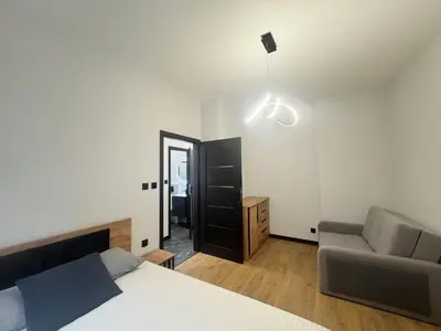 a bedroom with a bed and a chair and a mirror at Pawlikowskiego nest - 5 minutes walk to Main Square in Kraków