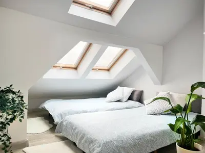 two beds in a attic room with skylights at Spacious Apartment with 5 bedrooms and 2 bathrooms for 12 guest in Cracow Old Town in Kraków