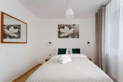 a bedroom with a white bed and a window at Tauron Arena Homely Apartment by BookingHost in Kraków