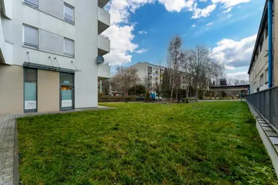 a grassy yard in front of a building at Tauron Arena Homely Apartment by BookingHost in Kraków