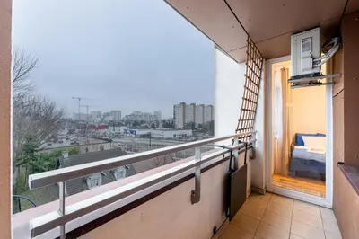 a balcony with a bed and a view of a city at Tauron Arena Homely Apartment by BookingHost in Kraków