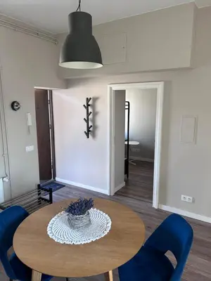 a dining room with a table and blue chairs at Apartament lawendowy in Kraków