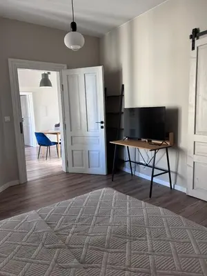 a tv sitting on a desk in a room with a door at Apartament lawendowy in Kraków