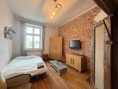 a room with a bed and a brick wall at Vintage Dajwor - in the center of Kazimierz in Kraków