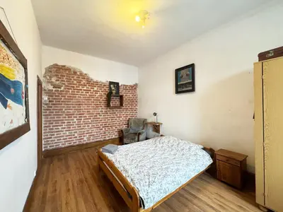 a bedroom with a bed and a brick wall at Vintage Dajwor - in the center of Kazimierz in Kraków
