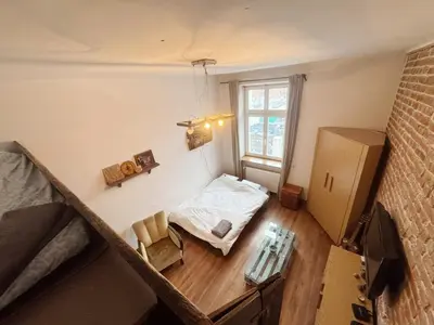 a small room with a bed and a window at Vintage Dajwor - in the center of Kazimierz in Kraków