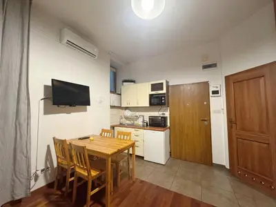 a small kitchen with a wooden table and a dining room at Paulinska paradise in Kraków