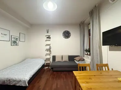 a bedroom with a bed and a couch and a shelf at Paulinska paradise in Kraków