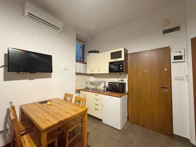 a kitchen with a wooden table and a kitchen with a television at Paulinska paradise in Kraków