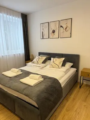 a bedroom with a large bed with two towels on it at Mickiewicz House Apartamenty in Wadowice