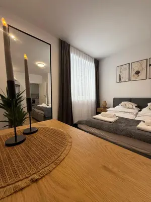 a bedroom with a large bed and a large mirror at Mickiewicz House Apartamenty in Wadowice