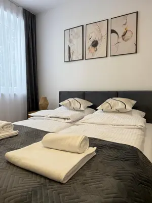 two beds with towels on top of them in a bedroom at Mickiewicz House Apartamenty in Wadowice