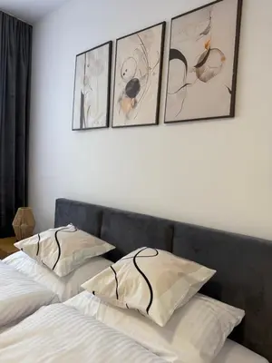 two beds in a bedroom with four pictures on the wall at Mickiewicz House Apartamenty in Wadowice
