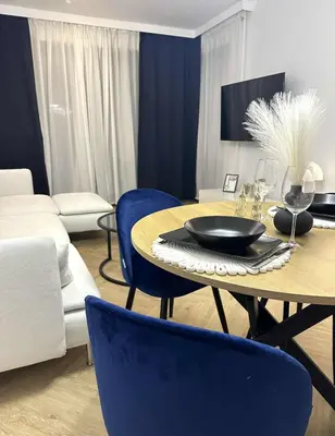 a dining room with a table and blue chairs at Luxury Apartment with Garden Krakow in Kraków