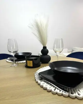 a table with a black plate and two wine glasses at Luxury Apartment with Garden Krakow in Kraków