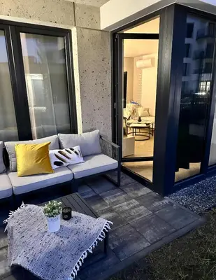 a living room with a couch and a table and a patio at Luxury Apartment with Garden Krakow in Kraków