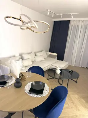 a living room with a table and blue chairs at Luxury Apartment with Garden Krakow in Kraków