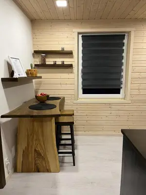 a kitchen with a table and a window with a blind at Apartament Pod Dębiną