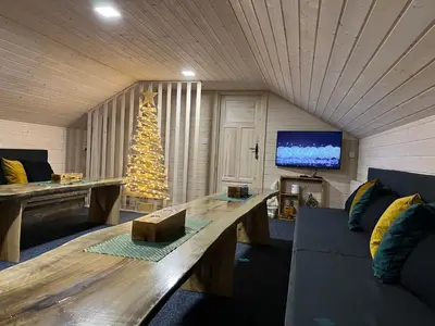 a living room with a large wooden table and a christmas tree at Apartament Pod Dębiną
