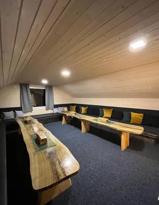 a row of benches in a room with wooden ceilings at Apartament Pod Dębiną