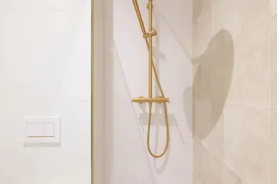 a shower with a brass shower head in a bathroom at Pawlikowskiego 12 by Homeprime in Kraków