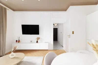 a white living room with a tv on a white wall at Pawlikowskiego 12 by Homeprime in Kraków