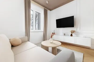 a white living room with a white couch and a tv at Pawlikowskiego 12 by Homeprime in Kraków
