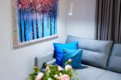 a living room with a couch and a painting on the wall at Cozy & Modern Apartments, Old Town in Kraków
