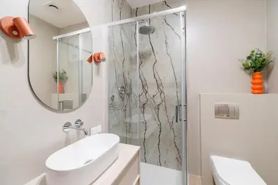 a bathroom with a shower and a sink and a mirror at Cozy & Modern Apartments, Old Town in Kraków