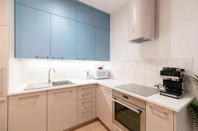 a white kitchen with a sink and a microwave at Cozy & Modern Apartments, Old Town in Kraków