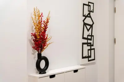 a black vase with flowers in it on a shelf at Cozy & Modern Apartments, Old Town in Kraków
