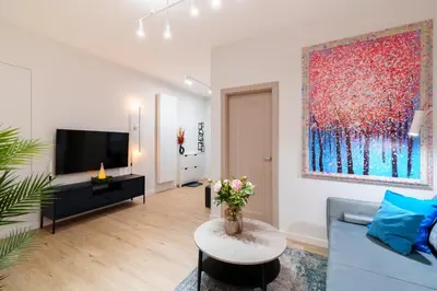 a living room with a blue couch and a large painting at Cozy & Modern Apartments, Old Town in Kraków