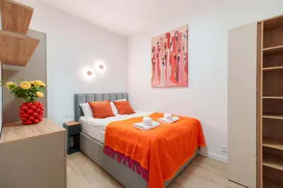 a bedroom with a bed with an orange blanket at Cozy & Modern Apartments, Old Town in Kraków