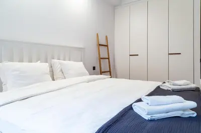 a bedroom with a bed and a wooden dresser with a bed sqor at Househost Apartment Szlak 77 Angel City in Kraków