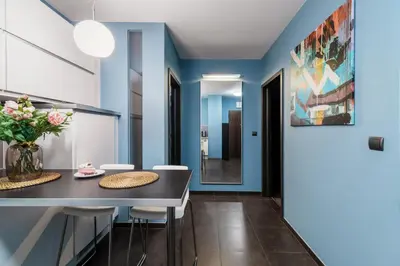 a dining room with blue walls and a table and chairs at Apartament Old Town Comfort Balkon & Parking in Kraków