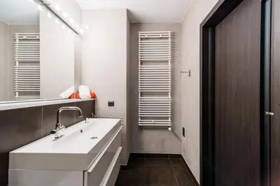 a bathroom with a white sink and a mirror at Apartament Old Town Comfort Balkon & Parking in Kraków
