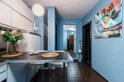 a kitchen with blue walls and a table with stools at Apartament Old Town Comfort Balkon & Parking in Kraków