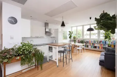 a kitchen and living room with a table and chairs at Sunny 2B apartment in City Centre in Kraków