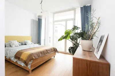 a bedroom with a bed and some plants in it at Sunny 2B apartment in City Centre in Kraków