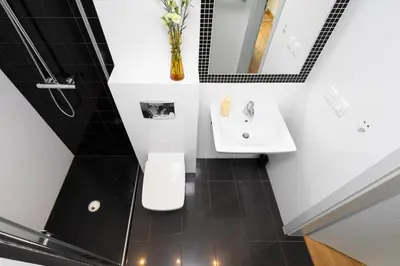 a bathroom with a sink and a toilet and a mirror at Sunny 2B apartment in City Centre in Kraków
