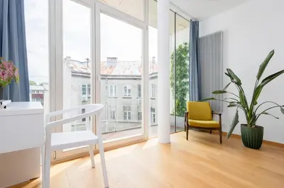 a living room with a table and a yellow chair at Sunny 2B apartment in City Centre in Kraków