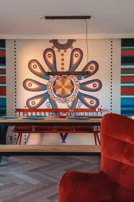 a painting on the wall in a room with a red chair at Muciówka in Jurków
