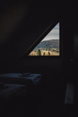a window in a dark room with a view of a mountain at Muciówka in Jurków
