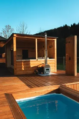 a wooden deck with a house and a swimming pool at Muciówka in Jurków