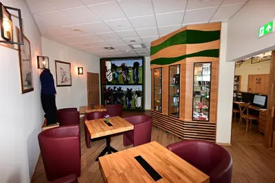 a restaurant with wooden tables and purple chairs at Stay at Royal Kraków Golf