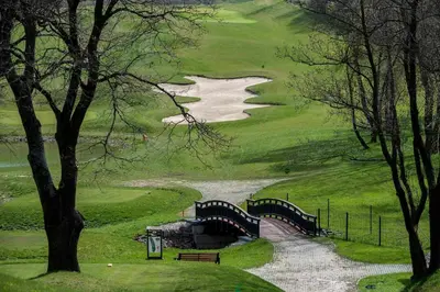 a bridge over a river on a golf course at Stay at Royal Kraków Golf