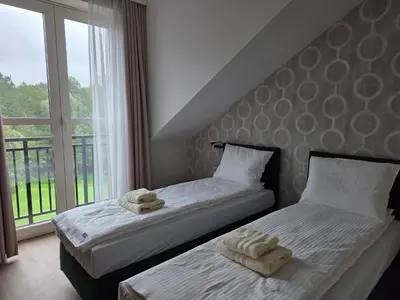 two beds sitting next to a window with towels on them at Stay at Royal Kraków Golf